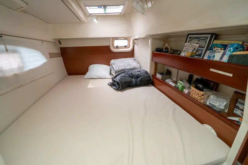 Slide: The Image of Cozy cabin interior of a 2011 Leopard 38 catamaran with bed and storage shelves. - 123