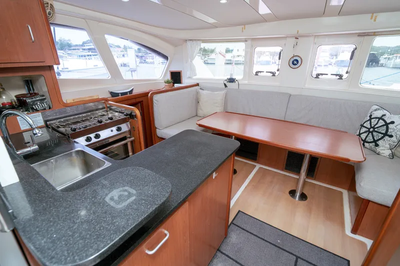 Slide: The Image of Interior of a 2011 Leopard 38 catamaran featuring a cozy dining area and modern kitchen. - 140