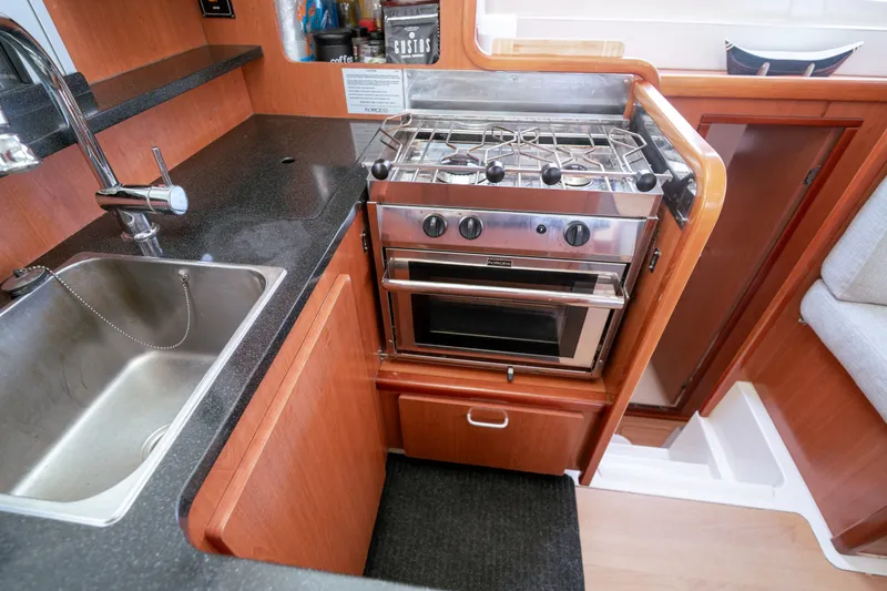 Slide: The Image of Compact kitchen area in a 2011 Leopard 38 yacht with stove and sink. - 131