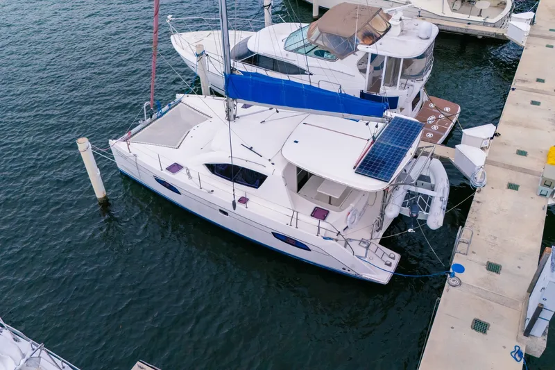 Slide: The Image of 2011 Leopard 38 catamaran docked, featuring solar panels and spacious deck. - 7