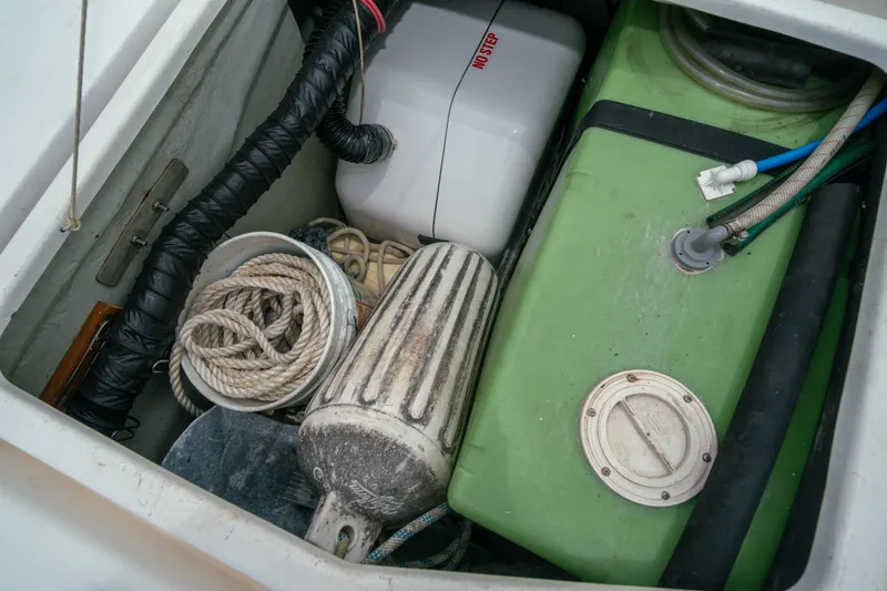 Slide: The Image of Boat storage compartment with ropes, fender, and green tank in a 2011 Leopard 38. - 150