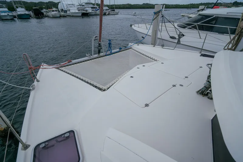 Slide: The Image of 2011 Leopard 38 catamaran docked at marina, featuring spacious deck and netting. - 35