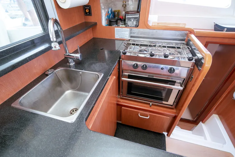 Slide: The Image of Compact kitchen in a 2011 Leopard 38 yacht with sink and stove. - 132