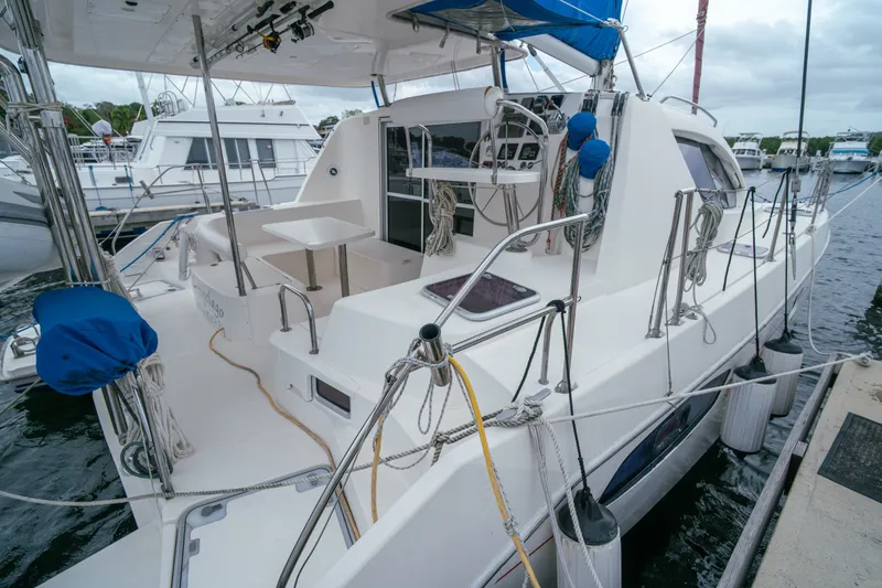 Slide: The Image of 2011 Leopard 38 catamaran docked at marina, featuring spacious deck and modern design. - 49