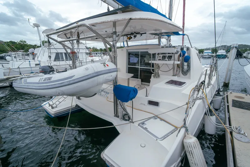 Slide: The Image of 2011 Leopard 38 catamaran docked with dinghy, featuring spacious deck and modern amenities. - 8