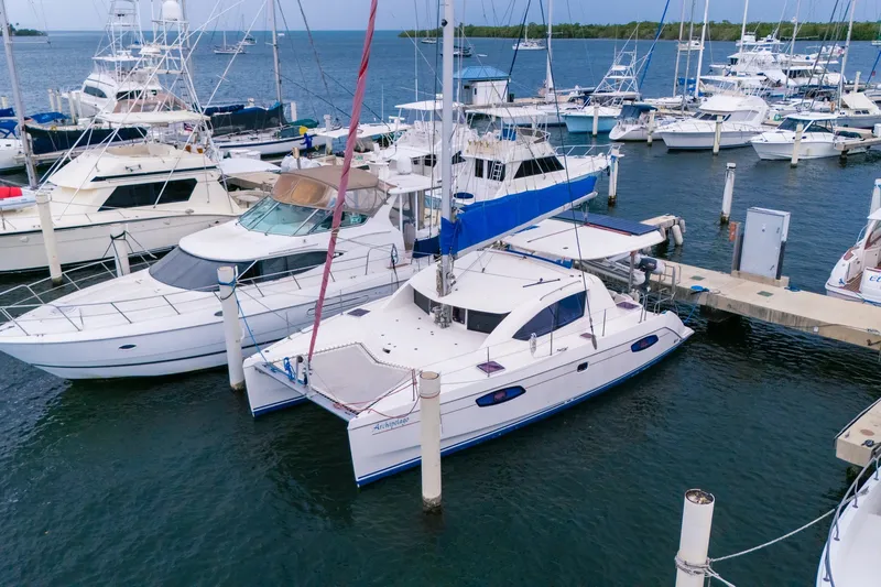 Slide: The Image of 2011 Leopard 38 catamaran docked at a marina, surrounded by various boats. - 0