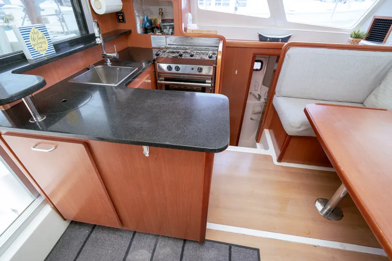 Slide: The Image of Modern kitchen interior of 2011 Leopard 38 catamaran with wood cabinetry and dining area. - 130