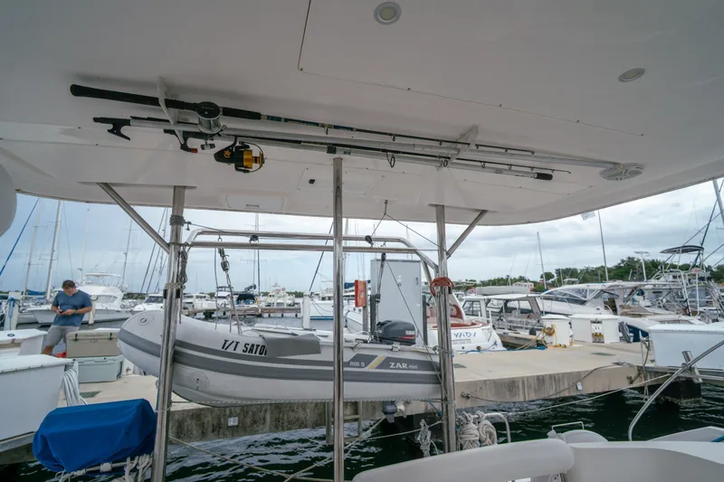 Slide: The Image of 2011 Leopard 38 yacht with dinghy at marina, showcasing fishing rod storage and docked boats. - 62