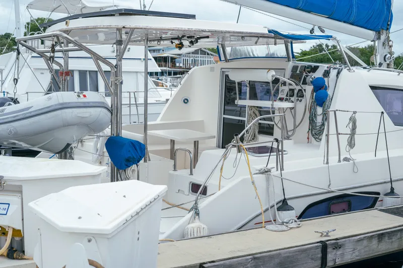 Slide: The Image of Leopard 38 catamaran from 2011 docked, featuring a dinghy and sailing equipment. - 73