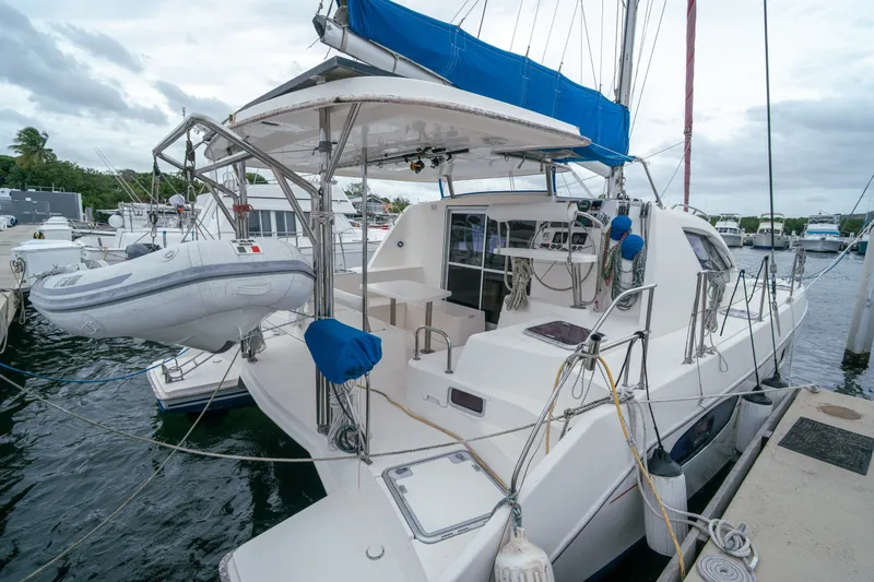 Slide: The Image of 2011 Leopard 38 catamaran docked, featuring a spacious deck and inflatable dinghy. - 18