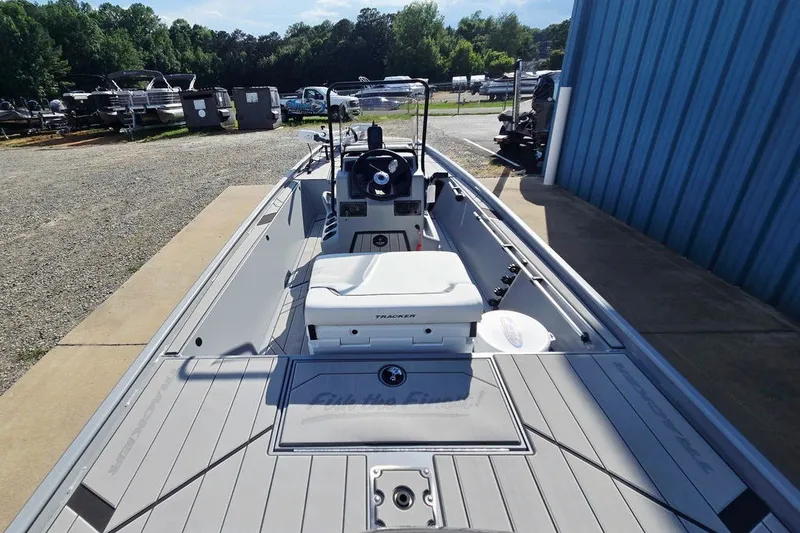Slide: The Image of 2027 Tracker Bass Tracker Classic CC boat docked near a blue building. - 24