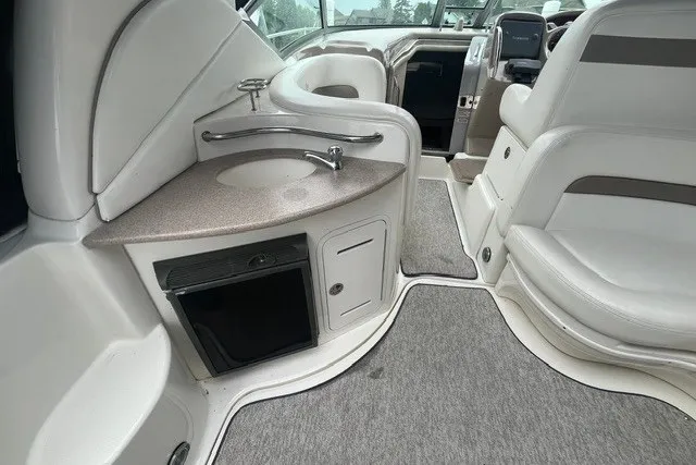 Slide: The Image of 2004 Sea Ray Sundancer 320 interior with sink, seating, and helm, showcasing luxury design. - 6