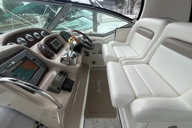 Slide: The Image of 2004 Sea Ray Sundancer 320 cockpit with white seating and modern navigation equipment. - 14