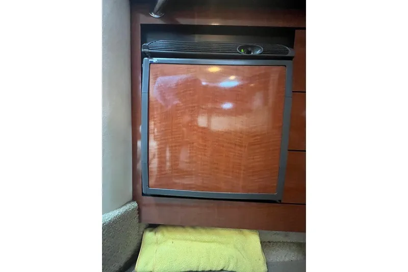 Slide: The Image of Wood-paneled mini fridge inside 2004 Sea Ray Sundancer 320 yacht cabin. - 26