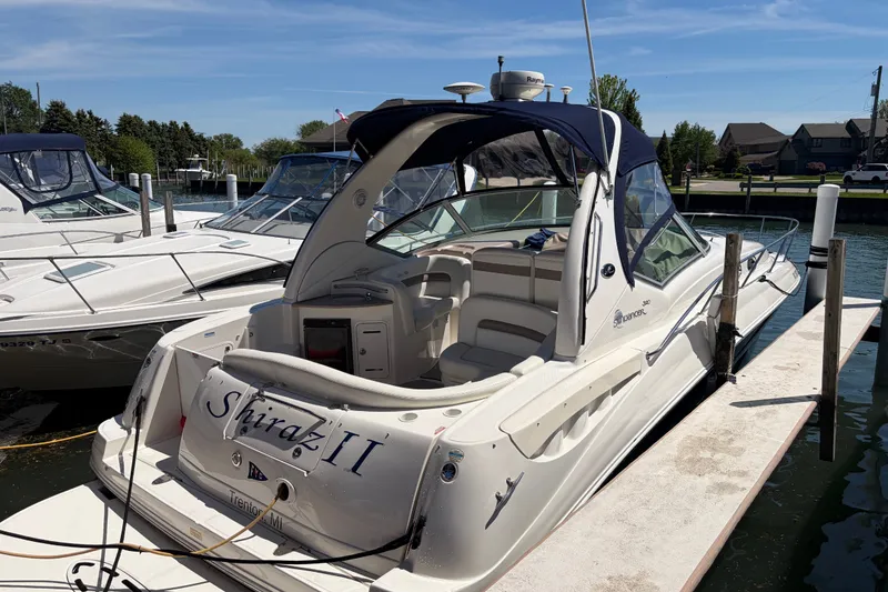Slide: The Image of 2004 Sea Ray Sundancer 320 docked, featuring sleek design and spacious seating. - 1