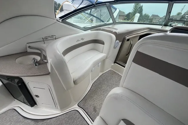 Slide: The Image of Interior of a 2004 Sea Ray Sundancer 320 boat, featuring plush seating and a compact sink. - 8