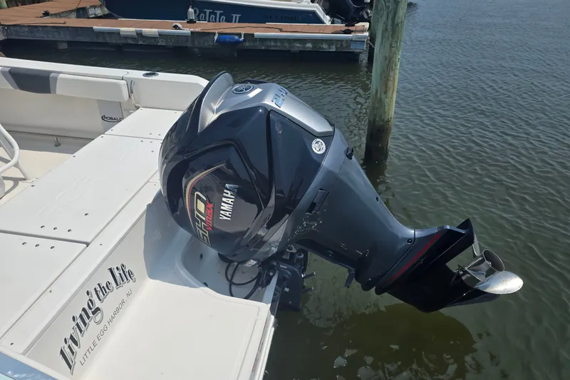 Slide: The Image of 2022 Robalo R230 Center Console with Yamaha outboard motor docked by water. - 18