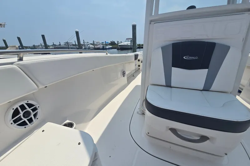 Slide: The Image of 2022 Robalo R230 Center Console boat interior with seating and speaker, docked at marina. - 10