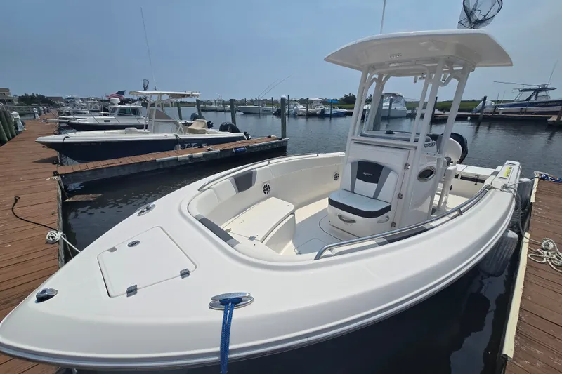 Slide: The Image of 2022 Robalo R230 Center Console boat docked at marina, showcasing sleek design and spacious deck. - 7