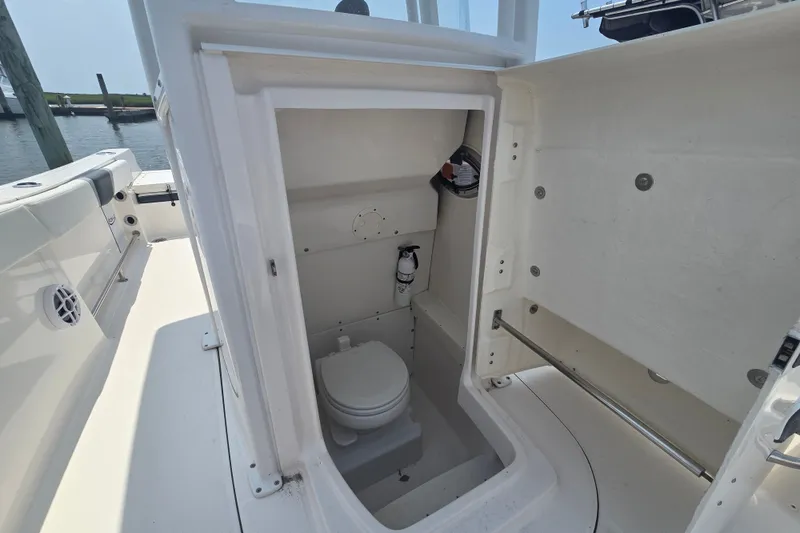 Slide: The Image of 2022 Robalo R230 Center Console boat interior with compact marine toilet. - 16