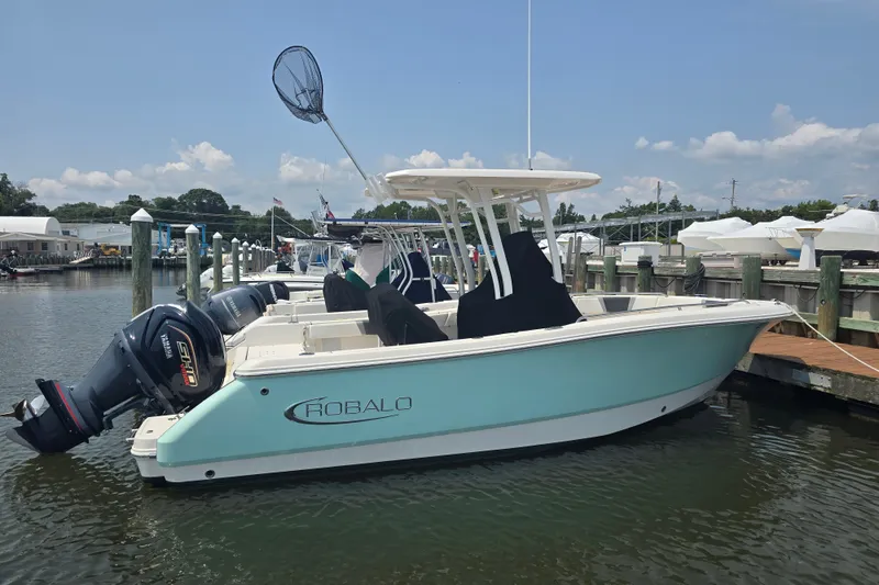 Slide: The Image of 2022 Robalo R230 Center Console boat docked at marina, featuring dual outboard engines. - 3