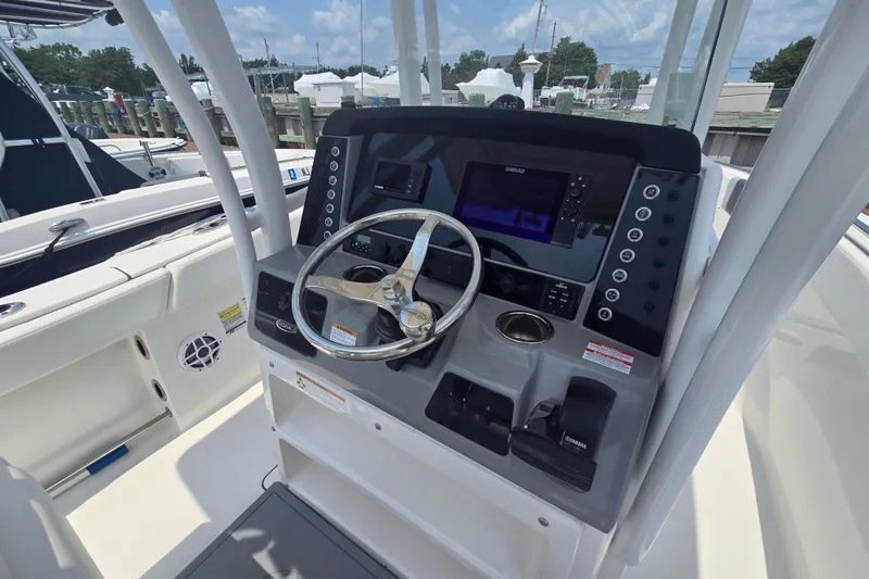 Slide: The Image of 2022 Robalo R230 Center Console boat dashboard with steering wheel and navigation controls. - 12