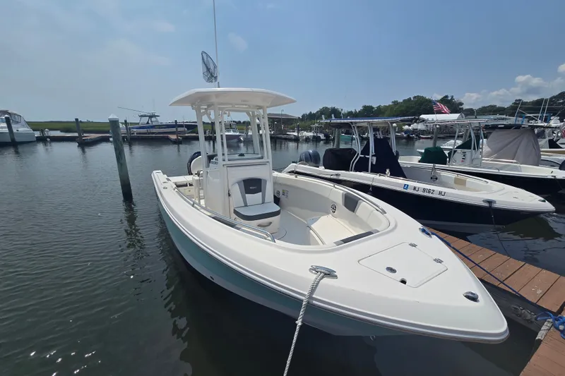 Slide: The Image of 2022 Robalo R230 Center Console boat docked in a marina under clear skies. - 5