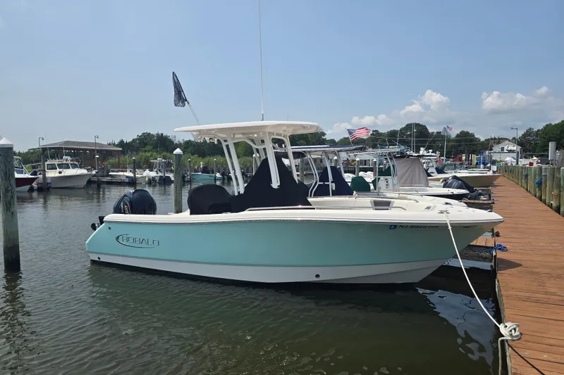 Slide: The Image of 2022 Robalo R230 Center Console boat docked at a marina on a sunny day. - 4