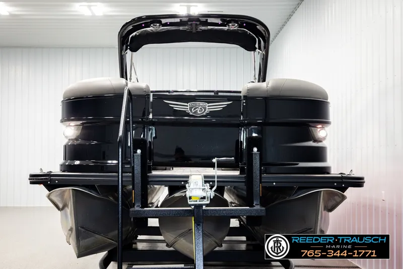 Slide: The Image of 2021 Avalon EXCALIBUR pontoon boat in showroom, featuring sleek black design and modern lighting. - 8