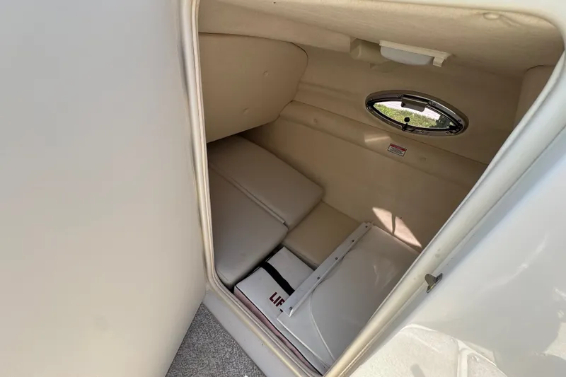 Slide: The Image of Interior cabin of 2003 Searay 270 Sundeck boat, featuring compact seating and a small window. - 20