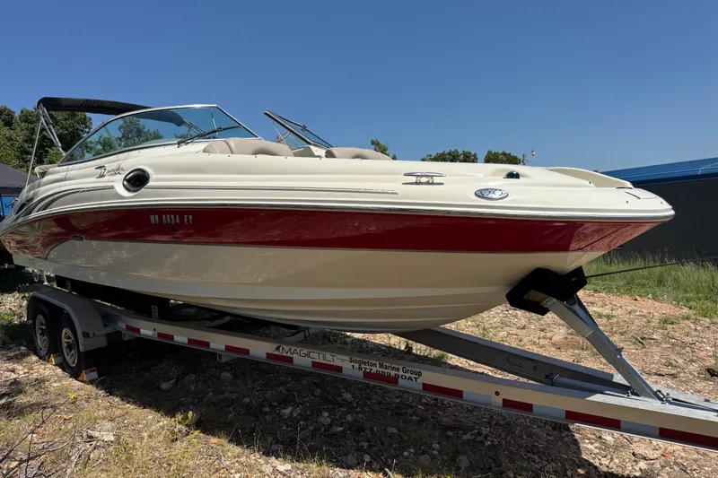 Slide: The Image of 2003 Searay 270 Sundeck boat on trailer, red and white exterior, sunny day. - 2