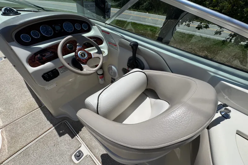 Slide: The Image of 2003 Searay 270 Sundeck helm with steering wheel, gauges, and comfortable seating. - 10