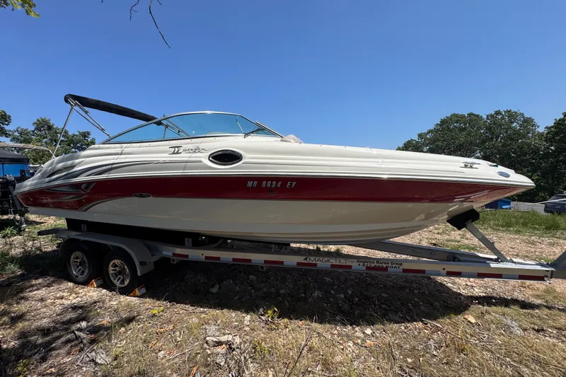 Slide: The Image of 2003 Searay 270 Sundeck boat on trailer, parked outdoors under clear blue sky. - 3