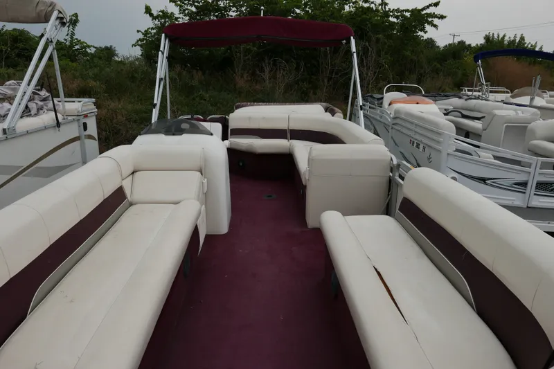 Slide: The Image of 2002 Avalon Tahoe Vista pontoon boat with maroon and white seating, docked outdoors. - 4