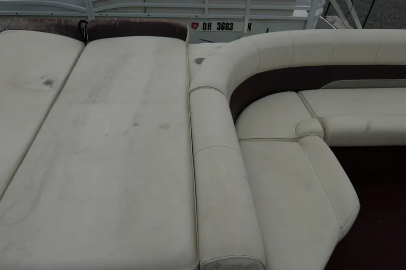 Slide: The Image of 2002 Avalon Tahoe Vista boat interior with white and maroon seating, showing wear and dirt. - 12