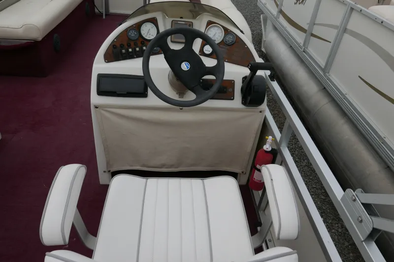 Slide: The Image of Steering console of a 2002 Avalon Tahoe Vista boat with gauges and fire extinguisher. - 10