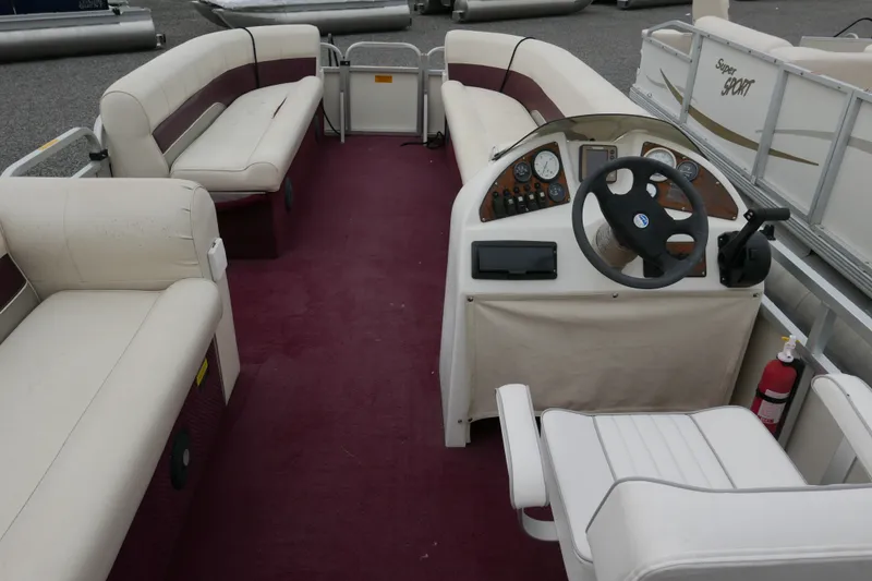 Slide: The Image of 2002 Avalon Tahoe Vista pontoon boat interior with maroon carpet and white seating. - 13