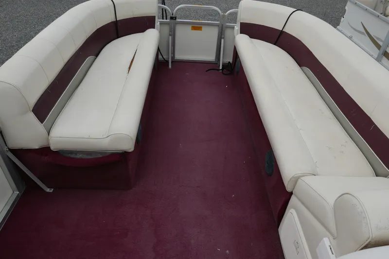 Slide: The Image of Interior of 2002 Avalon Tahoe Vista boat with maroon carpet and white seating. - 7