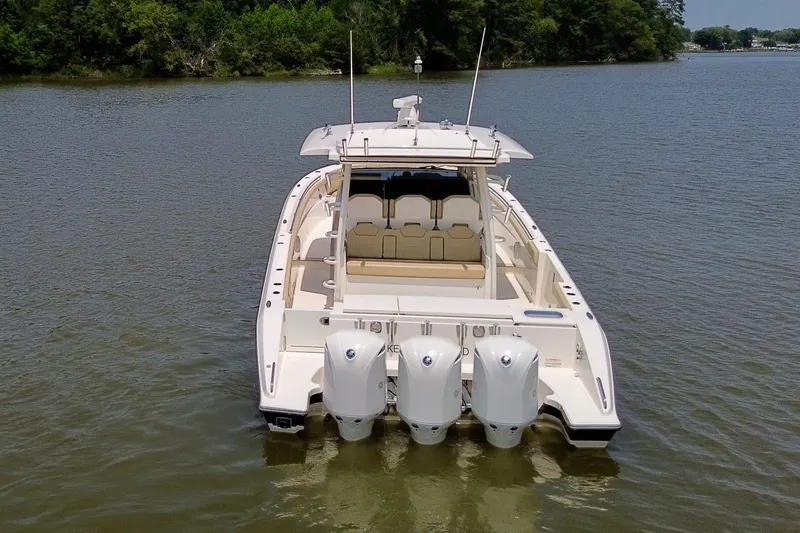 Slide: The Image of 2017 Pursuit S 408 Sport boat on calm water, rear view with triple engines. - 17