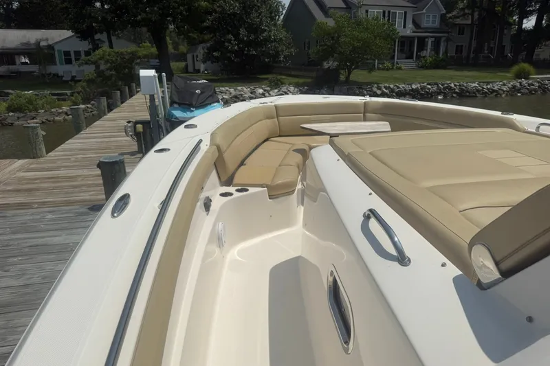 Slide: The Image of 2017 Pursuit S 408 Sport boat with beige seating, docked near waterfront homes. - 34