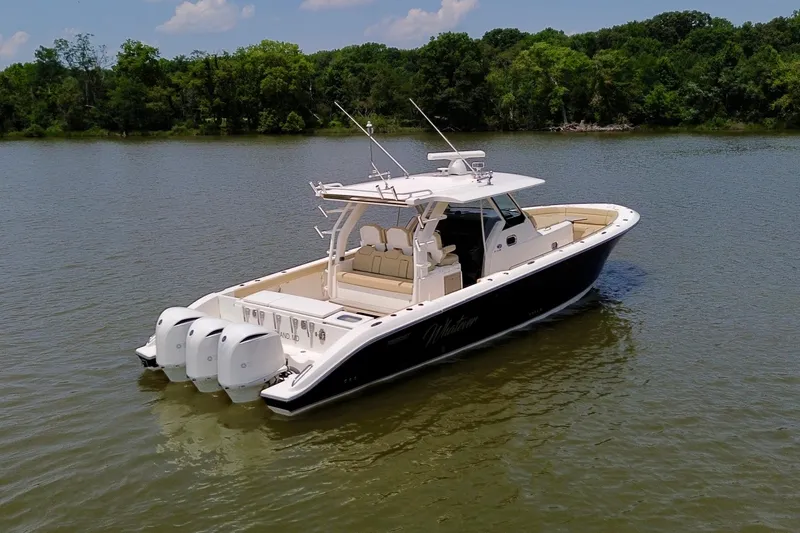Slide: The Image of 2017 Pursuit S 408 Sport boat on calm water, surrounded by lush greenery. - 18