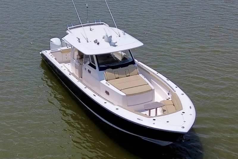Slide: The Image of 2017 Pursuit S 408 Sport boat on calm water, featuring sleek design and spacious deck. - 13