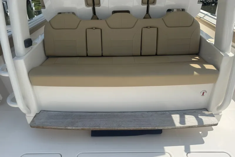Slide: The Image of 2017 Pursuit S 408 Sport boat with beige cushioned seating and wooden step. - 29