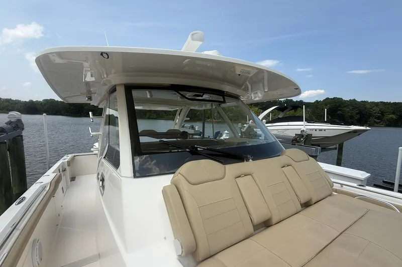 Slide: The Image of 2017 Pursuit S 408 Sport boat docked by a serene lake under a clear sky. - 57
