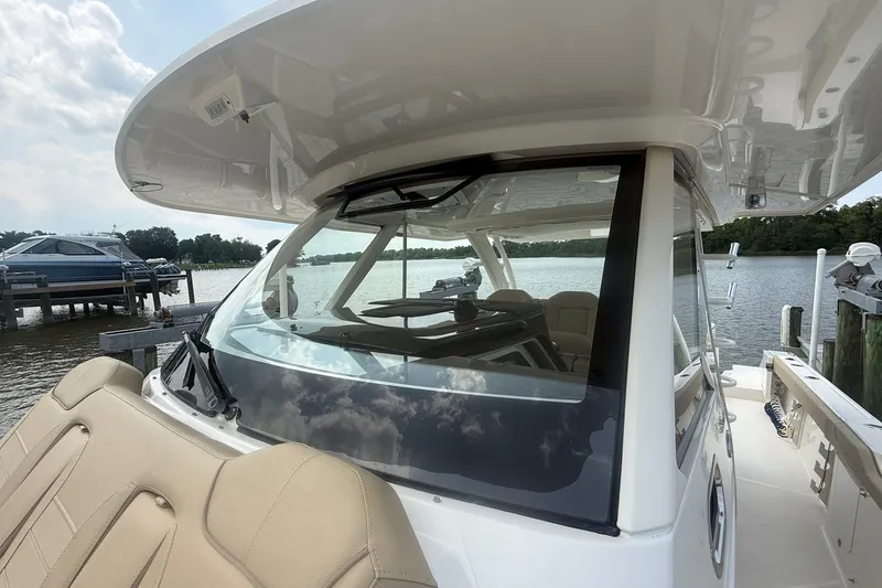 Slide: The Image of 2017 Pursuit S 408 Sport boat docked by a serene lake. - 56