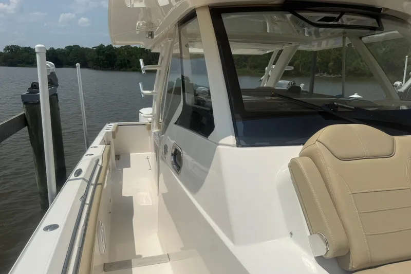Slide: The Image of 2017 Pursuit S 408 Sport boat docked by a serene lake. - 42