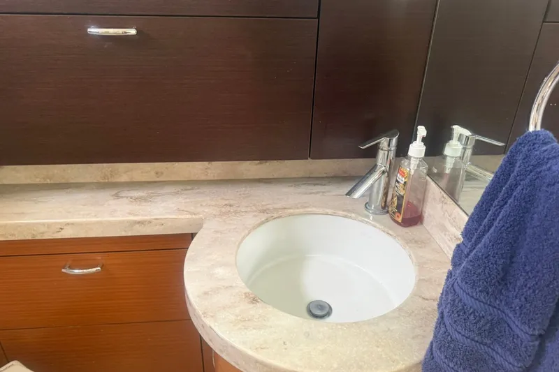 Slide: The Image of Marble sink area with towel and soap dispenser on a 2017 Pursuit S 408 Sport. - 46