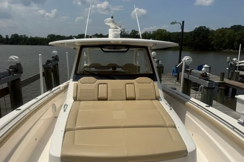 Slide: The Image of 2017 Pursuit S 408 Sport boat docked by a serene lake under a partly cloudy sky. - 40