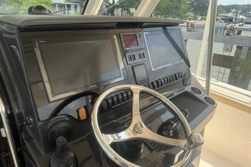 Slide: The Image of 2017 Pursuit S 408 Sport boat dashboard with steering wheel and navigation screens. - 21