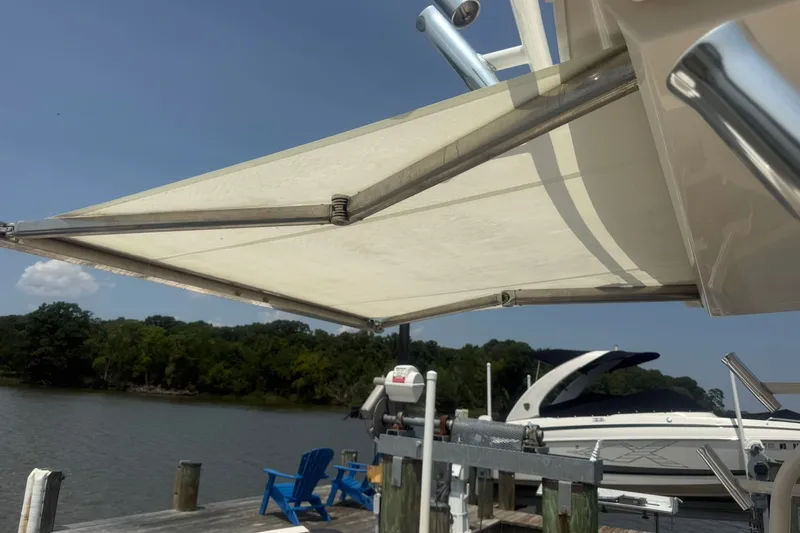 Slide: The Image of 2017 Pursuit S 408 Sport boat with canopy docked by a serene lake. - 19